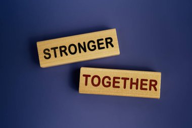 Stronger kelimeleri birlikte çok güzel bir lacivert arka planda tahta bloklara yazılmıştır. İş, motivasyon ve birlikte daha güçlü konsept
