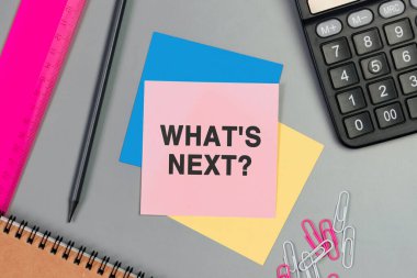 Sırada ne var? Yapışkan notla yazılmış metin. Pembe kartın, kalemin, hesap makinesinin ve masa üzerindeki ataçların en üstteki görüntüsü. Düz dizayn