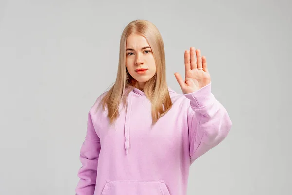 Seriöses Blondes Mädchen Zeigt Stoppschild Und Runzelt Missmutig Die Stirn — Stockfoto