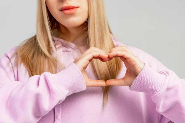 Blond Jente Med Krokete Øyne Som Lager Hjertesymbol Med Hendene – stockfoto