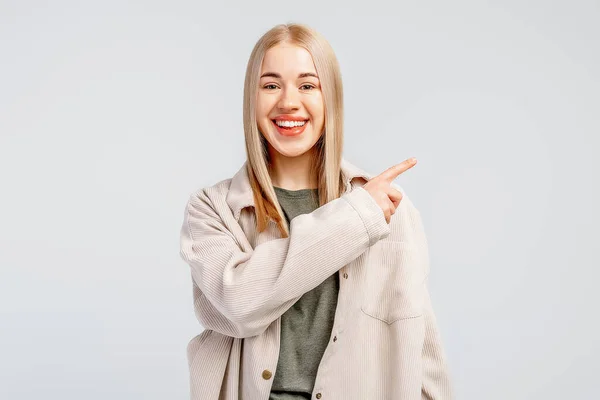 Leende Snygg Blond Flicka Trendig Skjorta Pekar Finger Höger Visar — Stockfoto