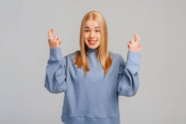 Umut dolu, hayalperest, gülümseyen ve hayal kuran genç bir kızın portresi, rüyaya olan inancı gerçekleşiyor, şans dileyin, dileyerek gri arka planda duruyor. Vücut dili kavramı