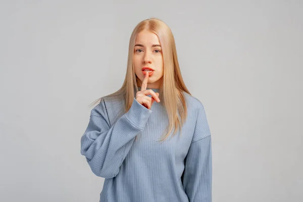 Портрет Серйозної Таємничої Блондинки Яка Позує Студії Тримаючи Палець Губах — стокове фото