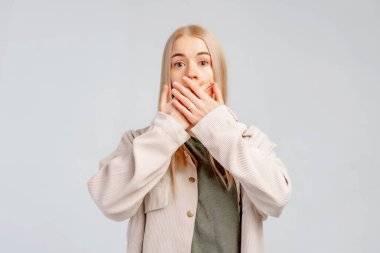 Korkmuş genç sarışın kadın kameraya bakıyor. Kocaman gözleri var. Elleriyle ağzını kapatıyor. Dehşete düşüyor. Negatif insan duyguları konsepti