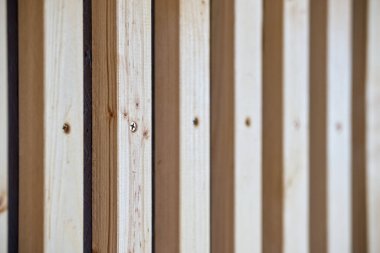 Ev terasında ince hafif tahtalardan yapılmış şık ahşap kürklerle dekore edilmiş bir duvar.