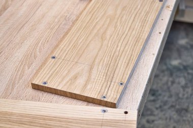 Kaplamalı, dişli kaplamalı MDF panelleri atölyedeki tezgahın üzerinde duruyor.