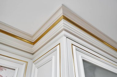 Kartonpiyer ve cam kapılı klasik stil ve klasik duvar paneli ile aydınlık ferah odada altın pervazlı kaplama