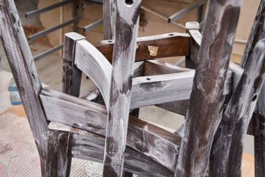 Geleneksel marangozluk atölyesinde zımpara kağıdıyla zımparalanan eski ahşap sandalyelerin ayrıntıları