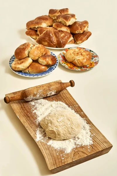 小麦粉からパイのための生の生地と木製のまな板と新鮮な自家製の甘いと肉パイの近くの白いテーブルの上にヴィンテージローリングピン — ストック写真
