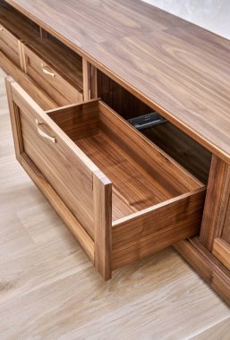 Zarif yeni televizyon dolabı. Kaplama ve saf ceviz kerestesinden yapılmış. Duvarın yanında altın saplı.