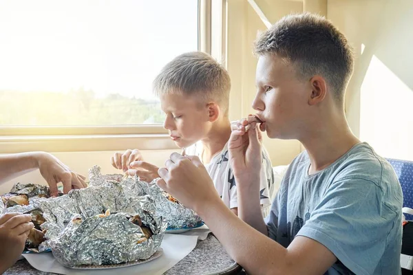 Blonde Schüler Essen Mittag Und Essen Gebratene Hühnchen Die Eisenbahnwaggon lizenzfreie Stockbilder