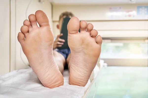 Piedi Nudi Scolaro Sdraiato Sul Letto Superiore Rack Con Biancheria Fotografia Stock