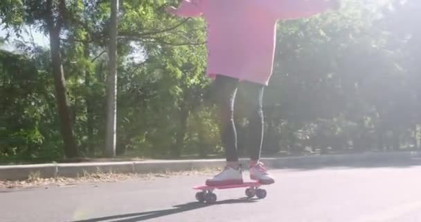 Młoda kobieta łyżwy trzęsie się na tablicy penny na drodze park — Wideo stockowe
