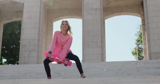 Mladá žena tančí na schodech drží penny palubě v rukou — Stock video