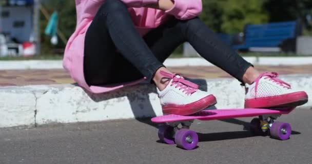 Femme joue avec penny conseil assis sur le trottoir par trottoir — Video