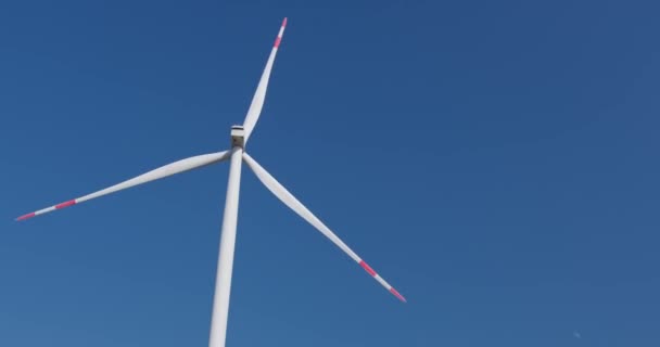 Turbine éolienne tourne derrière les techniciens avec dessin de projet — Video