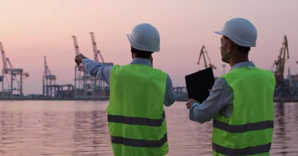 Hombres discuten regulación de grúas a través de walkie-talkie y tableta — Vídeos de Stock