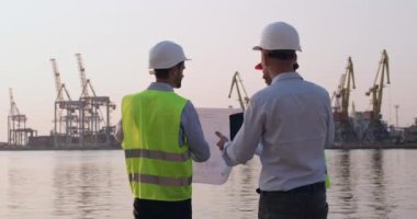 Erkekler inşaat sorunlarını taslak ve tabletle tartışıyor