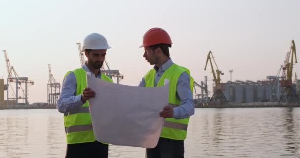 Port workers discuss crane building using delineation — Stock Video
