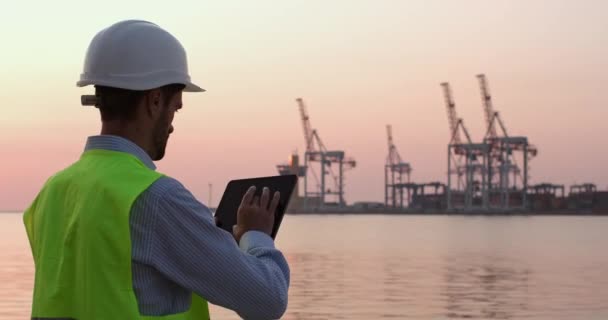 Man controls ships and portal cranes using tablet PC — Stock Video