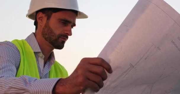 Человек смотрит на чертеж крана при строительстве крупным планом — стоковое видео