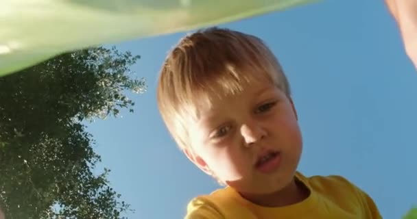 Αγόρι φροντίζει το περιβάλλον και συγκεντρώνει μπουκάλια στο πάρκο — Αρχείο Βίντεο