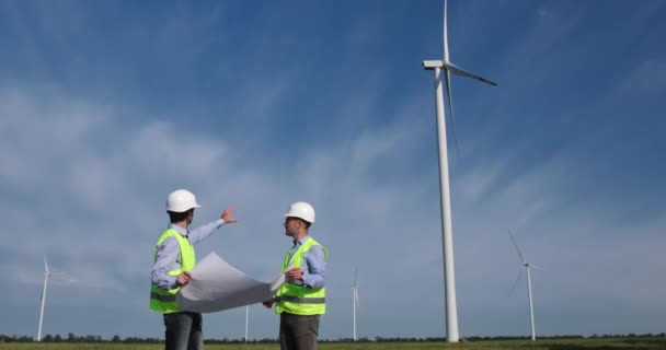 Inženýři drží výkresy a diskutují o opravách větrných mlýnů — Stock video