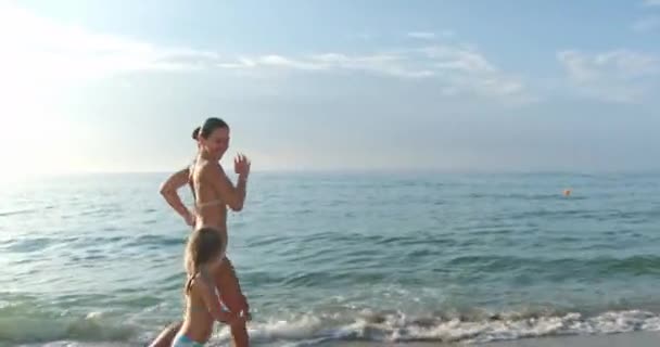 Mutter und Tochter spielen gemeinsam am Strand des Meeres — Stockvideo