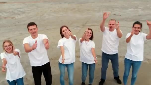 Men and women show thumbs-up and dance smiling broadly — Stockvideo