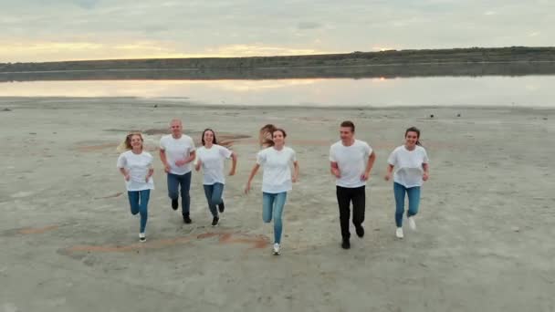 Boy and girl friends run with smiles on flat river bank — Wideo stockowe