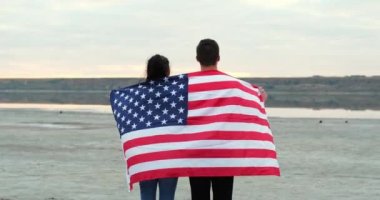 Çift, sakin nehre karşı Amerikan bayrağıyla kaplanmış duruyor