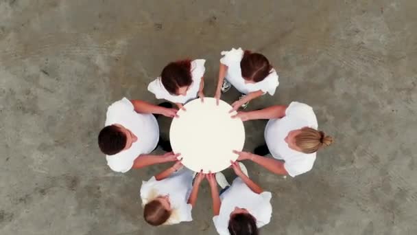 Groep vrienden houdt witte papieren cirkel bij elkaar — Stockvideo