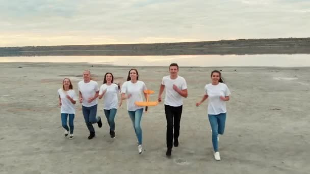 Vrienden team rennen en lanceren vliegtuig samen tegen de rivier — Stockvideo