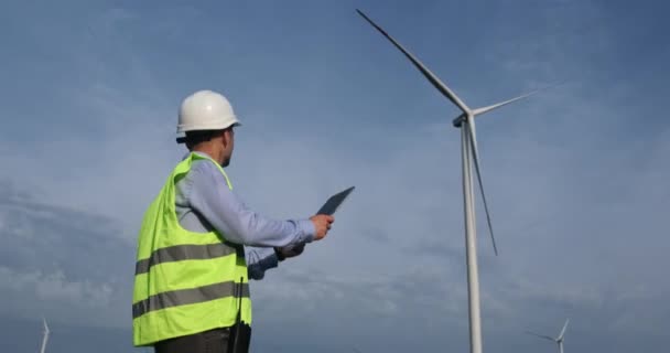 Ingeniero mira la construcción del molino de viento dibujo en la tableta PC — Vídeo de stock