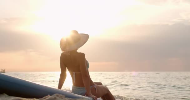 Mladá žena má výhled na moře sedí na SUP na písečné pláži — Stock video