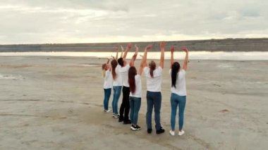 Dostlar el sallıyor, nehir kıyısında.