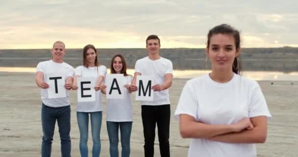 Tiener meisje toont duim-up tegen poseren team van vrienden — Stockvideo