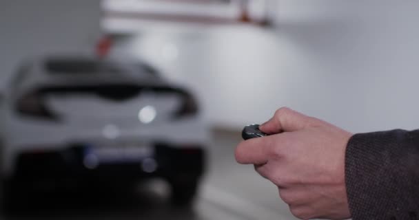 Mão de homem em primeiro plano desbloqueando carro estacionado com chave — Vídeo de Stock