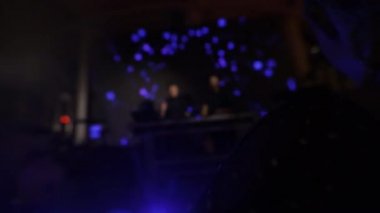 İnsanlar DJ konsolunda dans eden bir kadınla müzik çalıyorlar.