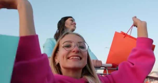 Nő lovagol bevásárlókocsiban tartó táskák és mosolygós — Stock videók