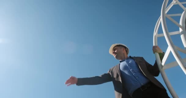 Homem cobre os olhos com palma da luz solar contra o céu azul — Vídeo de Stock