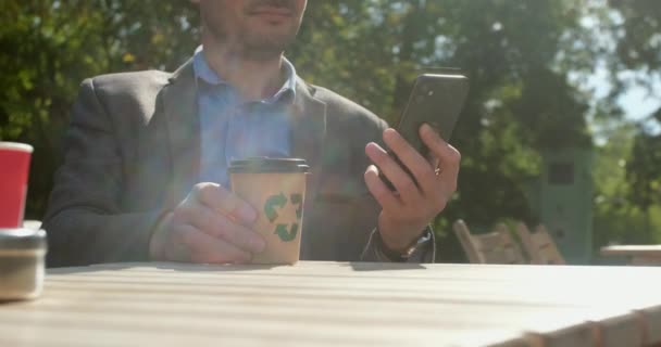 Man drinkt koffie in straat cafe het controleren van post in smartphone — Stockvideo