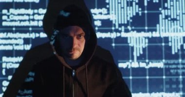 Angry man wearing black hoodie shrugs against digital screen