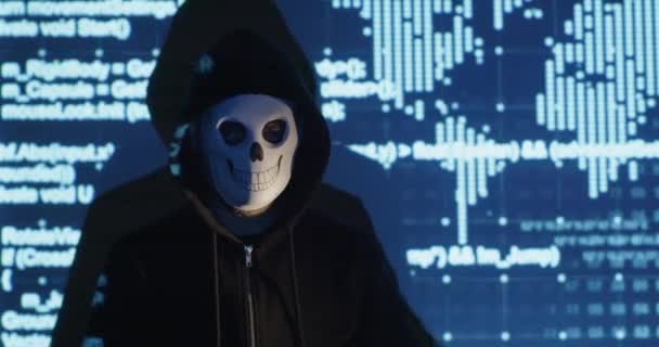 Hacker dalam hoodie dengan topeng tengkorak menunjukkan koin cryptocurrency — Stok Video