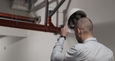 Male architect puts on helmet in underground parking lot