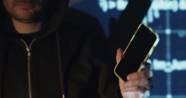 Programmer shows mobile phone against blue digital screen