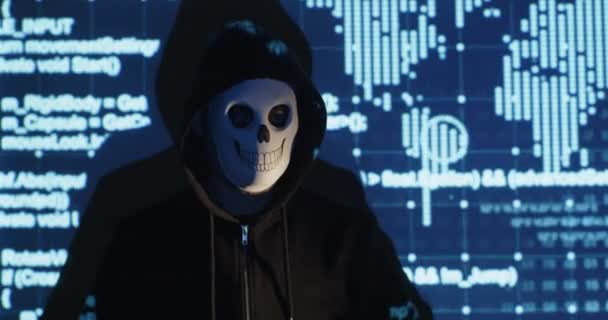 Hacker with skull mask shows smartphone with blank screen — Stockvideo