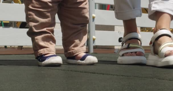 Mother Patiently Teaches Toddler Son Walk Outdoors White Fence Legs — Stock Video