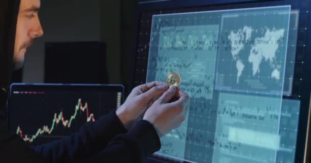 Άντρας Την Κουκούλα Κρατάει Χρυσό Νόμισμα Μπροστά Στην Οθόνη Σπάσιμο — Αρχείο Βίντεο