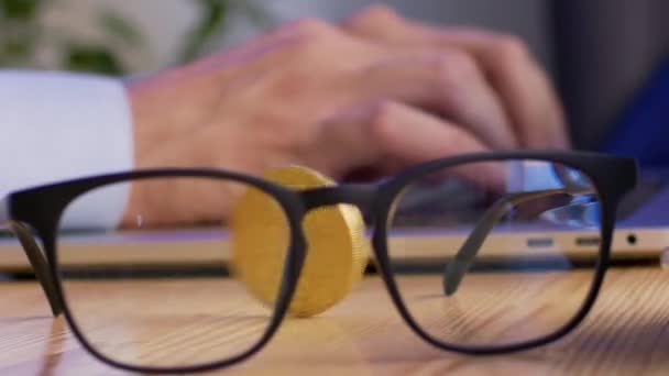 Golden Coin Spins Wooden Table Transparent Glasses Freelancer Strong Fingers — Stockvideo